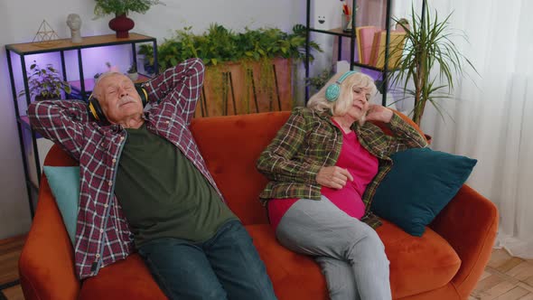 Happy Senior Family Grandparents Man Woman in Headphones Listening Music Relaxing on Couch at Home alt