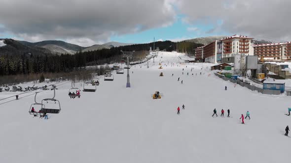 Aerial View on Lot of People Skiing on Ski Slopes Near Ski Lifts on Ski Resort alt