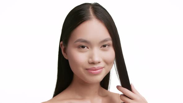 Korean Woman Brushing Brunette Hair With Comb Over White Background alt