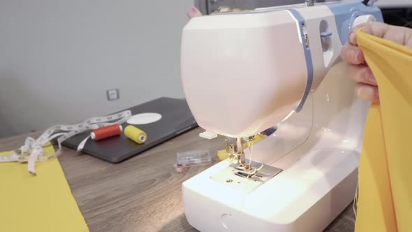 Female Hands Sew on a Sewing Machine