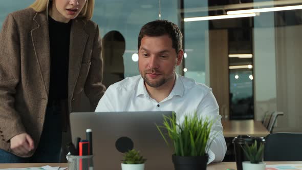 Young Businessman Working on Laptop at Desk in Modern Open Plan Start Up Office Being Joined By alt