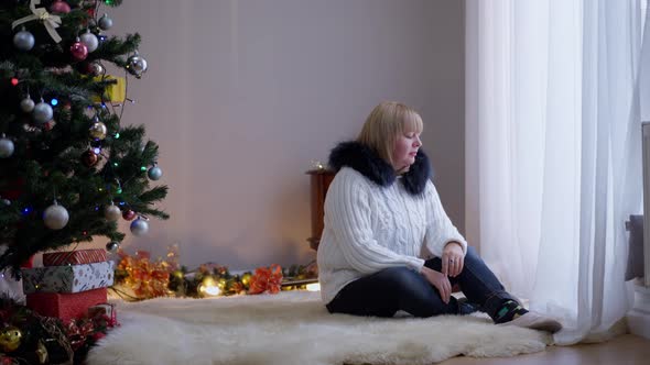 Frustrated Sad Woman Crying Alone on Christmas Eve As Santa Clause Entering Living Room with Present alt
