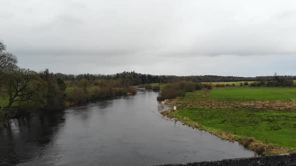 Aerial - Over the river with bridge road for car passing through. Small town of Jamestown, Ireland, alt
