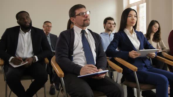 Diverse Multi Ethnic Audience Noting at Seminar alt