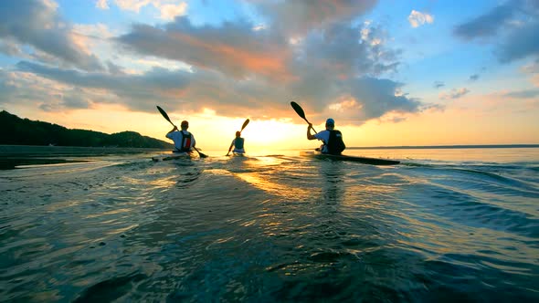 People Are Sailing on Canoes During Sunset alt