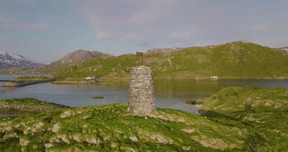 Drone rotation around rock cairn on islet near Sommaroy Bridge, Hillesoy area alt