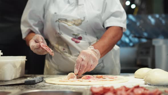 The Pizza Chef Iola Prepares The Pizza Dough For Baking The Chef Puts The Meat On The Prepared Round alt