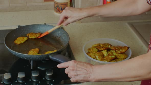 A Woman Puts Already Fried Cutlets From a Frying Pan Into a Bowl alt