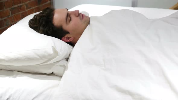 Young Man Falling Asleep in Bed at Night alt