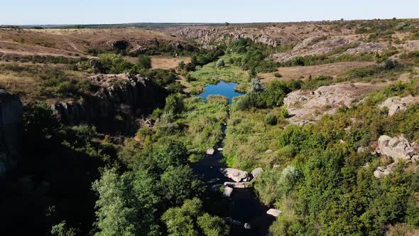 A Narrow Rocky Canyon with Trees and a Wide River