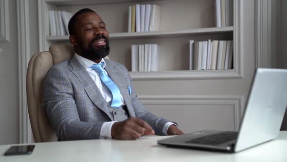 African-American Bearded Man in a Gray Suit and Shirt. The Businessman Is in a Bright Office at the alt