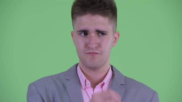 Face of Stressed Young Businessman Thinking and Looking Down alt