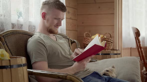 Handsome Student Resting Studing at Home, Reading Paper Book alt