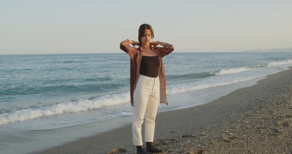 Young girl with black boots has fun on the beach near the sea in Italy alt