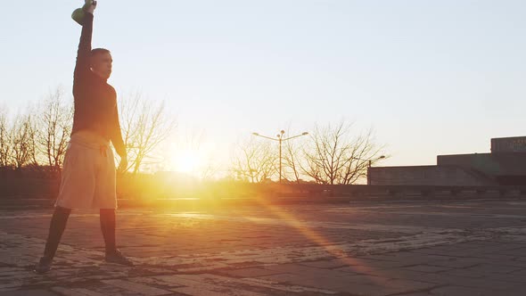 Young and fit man having evening workout outdoor. Urban sunset. alt