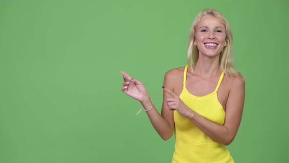 Young Happy Beautiful Blonde Woman Showing Something