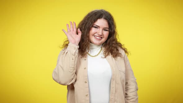 Coquette Smiling Plussize Woman Waving Looking at Camera Sending Air Kiss alt