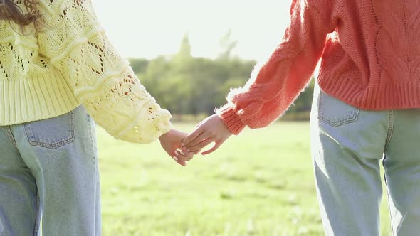 Female couple stop holding hands.