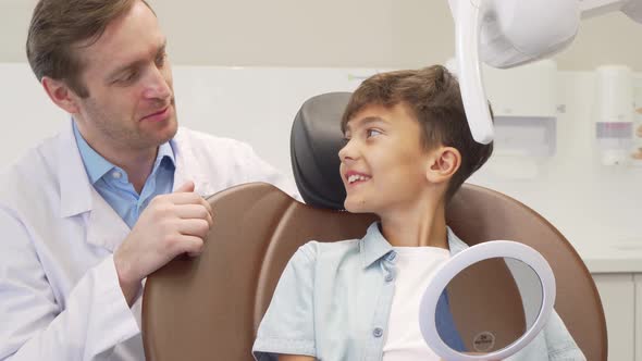 Mature Male Dentist Working with Charming Young Boy alt