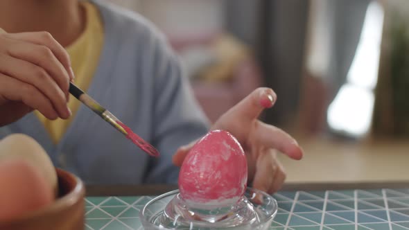 Hands of Girl Decorating Easter Egg with Paint alt
