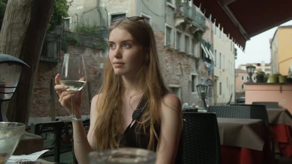 Young Beautiful Girl Drinks Wine in The Cafe of Venice