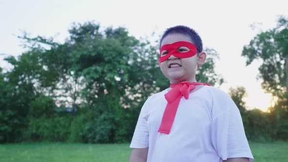 Asian boy wearing hero costume standing and smiling at the park alt