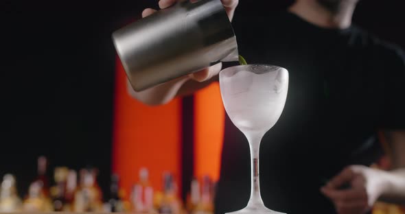 Bartender Pours Mixed Drink From the Shaker to the Frozed Highstemmed Glass Barman Makes Cocktail alt