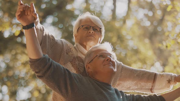 Happy Old Couple Dancing in Park. Senior Man Flirting with Elderly Woman. Romance at Old Age Autumn alt
