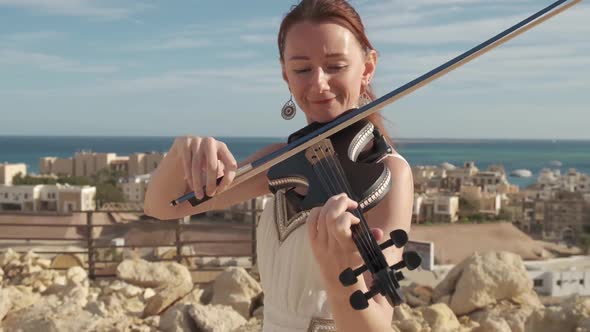 Red-haired woman is playing the violin