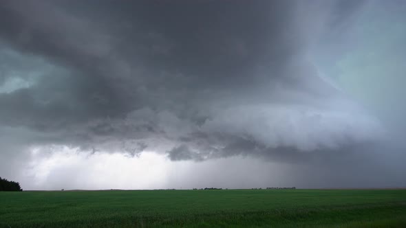 View of severe storm rolling over farm fields in Nebraska as lightning flashes alt