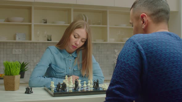 Confident Pretty Woman Defeating Male Opponent During Chess Game Indoors alt