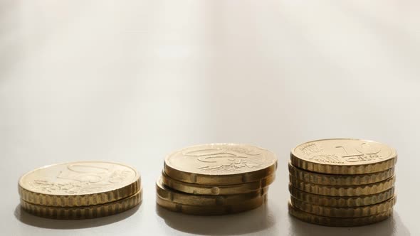 Lot of different values of Euro coins piles on table slow tilt 4K 2160p 30fps UltraHD footage - Mone alt