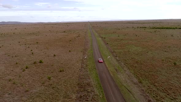 Aerial View Of Happy man Driving red Car Down Country Road