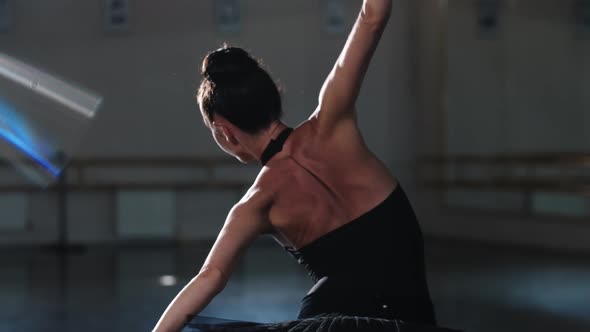 A Woman Ballerina in Black Tutu Dancing with Her Hands in the Studio alt