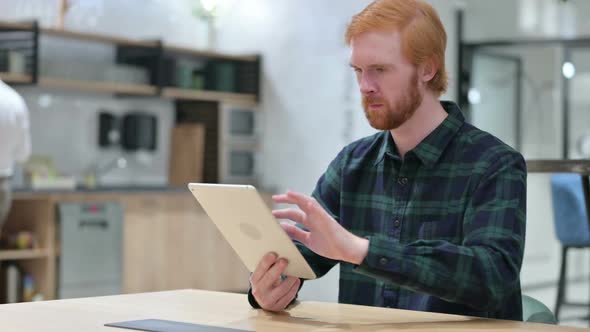 Young Beard Redhead Man Using Digital Tablet in Cafe alt