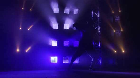 Silhouette of a Talented Young Hip Hop Dancer. Hip Hop Street Dance on a Stage in Dark Studio with alt
