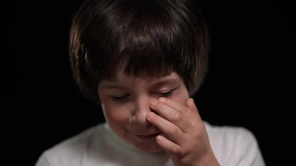 Headshot of Little Boy Crying Touching Painful Bruise on Face Looking at Camera alt