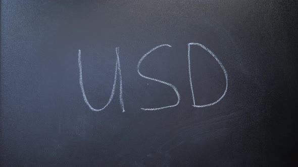 USD written on chalkboard. World currency. Hand writing USD with chalk on blackboard. alt