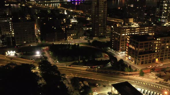 An aerial view at night over the Brooklyn Bridge entrance on the Brooklyn side. As traffices around alt