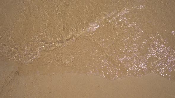 Slowmotion Shot. A Lettering COVID on the Sand Is Being Washed Away By the Sea. Concept of the End alt