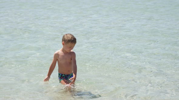 Child Splashes Joyfully Splashes in the Crystal Clear Sea