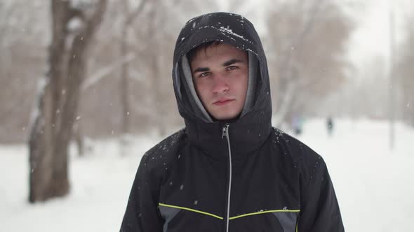 Man Stands in Park Winter and Looks at the Camera alt