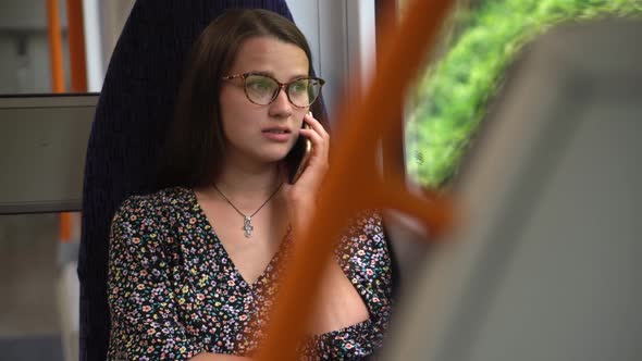 Close Shot of Young Attractive Ukraine Female in Glasses Sitting on Moving City Metro Train alt