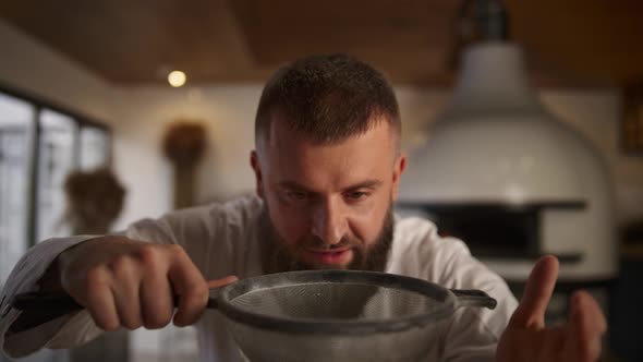 Baker Man Sifting Flour Using Sieve in Culinary Restaurant alt
