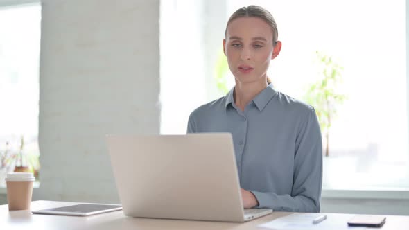 Woman Shaking Head in Rejection While Using Laptop in Office alt