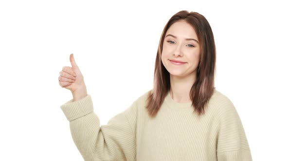 Halfturned Portrait of Friendly Adult Woman Looking at Camera with Smile Showing Thumb Up Meaning alt