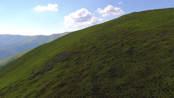 Aerial flight over green hill mountains. FPV Dynamic drone shot
