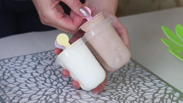 A Woman Pulls Out Ice Cream On A Stick From An Ice Cream Maker. Close Up Shot. alt