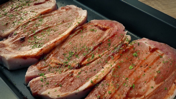 Pork Chops Are Prepared For Oven With Sauce And Herbs alt