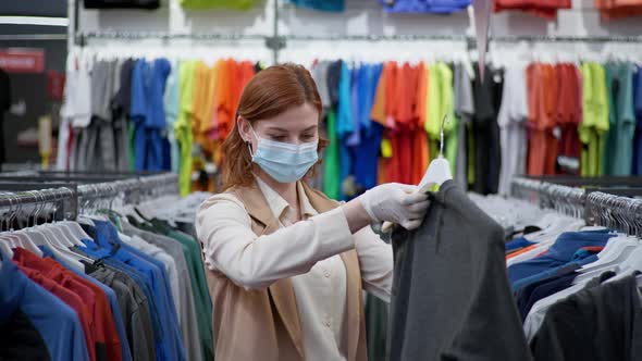 Shopping Quarantine, a Happy Female Customer Wearing Medical Masks and Gloves Chooses Clothes After alt